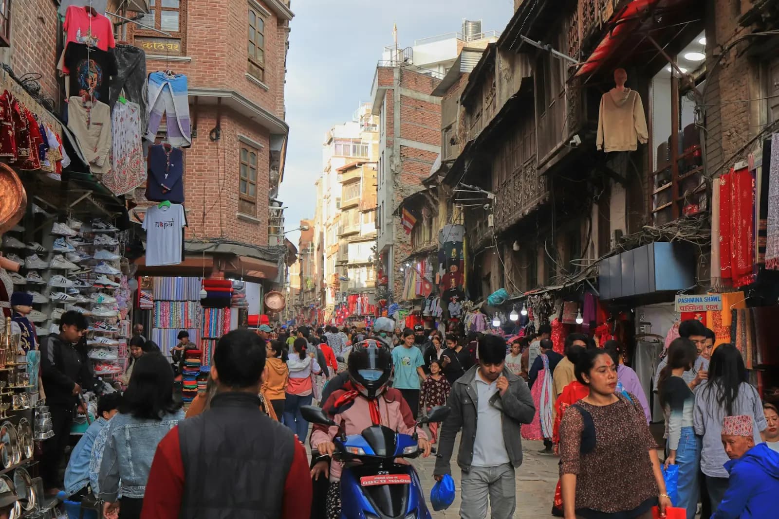 Shoppers and street stalls along a crowded market street in Kathmandu