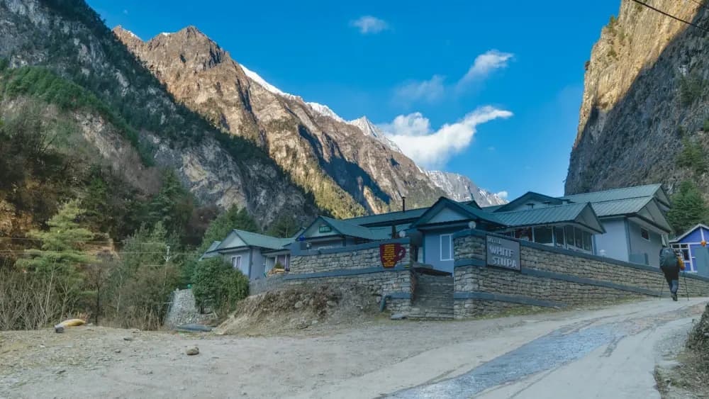 A guest house for trekkers in a Himalayan valley below snow-capped peaks