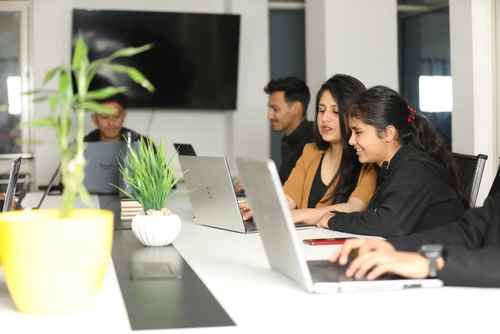 Young professionals working on laptops at a shared table in a Kathmandu coworking space